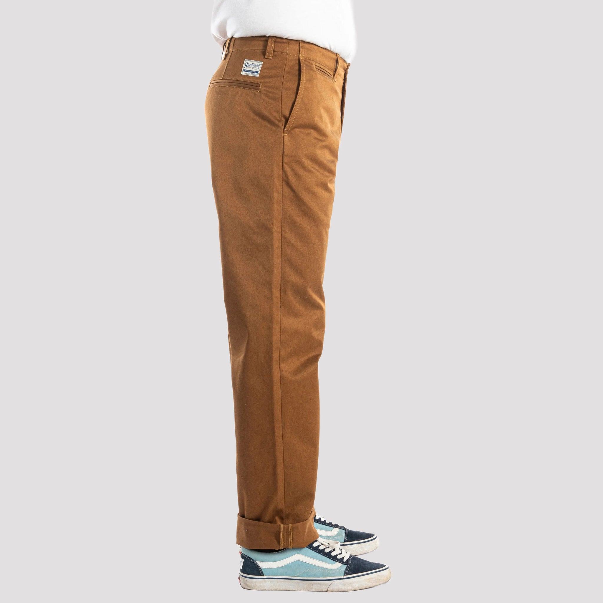 Brown pants worn by a person on a white background